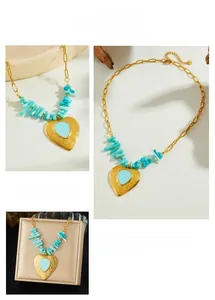 Detailed close-up of gold heart pendant necklace with irregular blue stones and beads