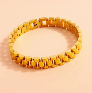 Detailed close-up of golden stainless steel strap bracelet showing the secure clasp