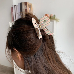 Detailed back view of a butterfly bow hair claw clip with pink heart and stripe patterns