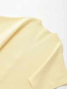 Detail of a bright yellow knit top showing the fine stitching and round neckline