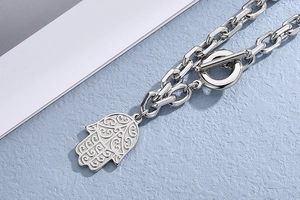 Close-up of silver Hamsa hand pendant necklace with toggle clasp and chunky chain link