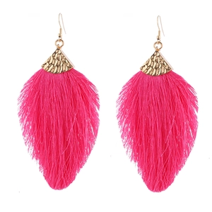 Detail of hot pink tassel earrings with hammered gold metal tops on white background