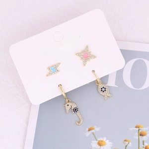 Set of four gold-plated stud earrings featuring lightning bolt, star, and sea life motifs