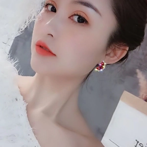Gros plan d'un mannequin portant des boucles d'oreilles pastèque serties de cristaux