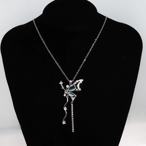 Détail du pendentif papillon argenté avec cristaux bleu clair et glands asymétriques
