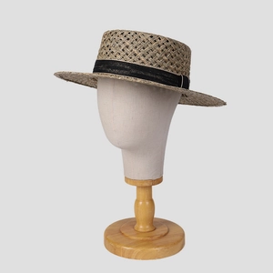 Flat top straw hat for women featuring hollow cross patterns and a black ribbon band
