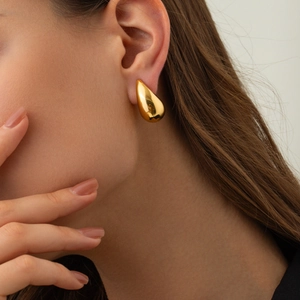 Minimalist 18K gold teardrop earrings worn by a model for a stylish fashion look