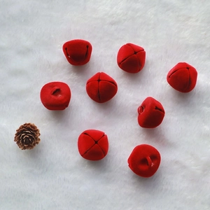 Set of eight 2.5cm red plush Christmas bells with pine cone on white faux fur background
