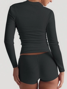 Rear view of black ribbed athletic two-piece set featuring long-sleeved top and mini skirt