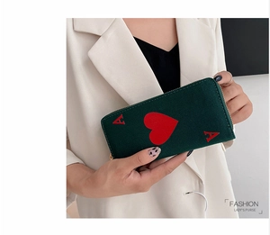 Deep green canvas clutch wallet with red heart Ace of Hearts print shown held by model