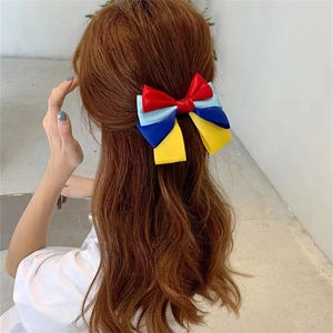 Detail of a colorful princess bow hair clip with ribbons on a girl's hairstyle