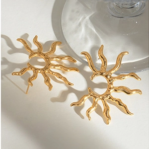 Detail shot of golden 18k stainless steel earrings with irregular sunburst wave pattern