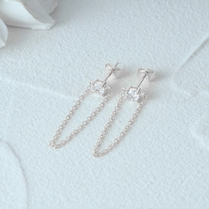 Macro detail of 925 sterling silver chain tassel earrings with sparkling white cubic zirconia