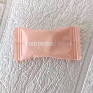 Close-up of a pink candy-shaped wrapper for a portable compressed cotton towel