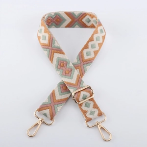 Detail of geometric jacquard woven bag strap with golden metal lobster clasps