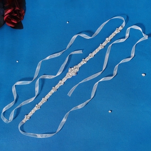 Detail of luxury bridal sash with clear rhinestones and white pearls on silver base