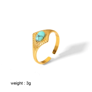 Retro gold stainless steel ring with turquoise oval gemstone on white background