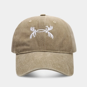 Detailed view of white antler embroidery on vintage khaki washed cotton baseball cap