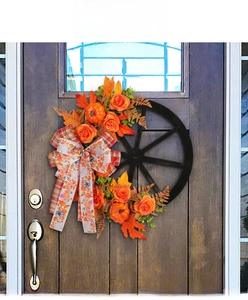 Rustic Thanksgiving harvest wreath featuring pumpkins and roses on a black wooden wheel