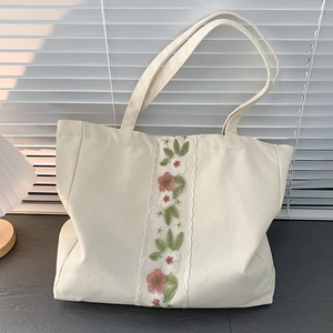 Borsa tote in tela ricamata con fiori e pizzo, capiente e in stile minimal su grigio