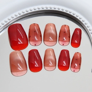 Red velvet cat eye press-on nails with amber jelly finish and black polka dots