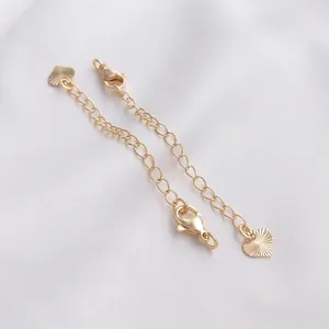 Detalle de cadenas de extensión bañadas en oro de 14K con cierres de mosquetón y corazones