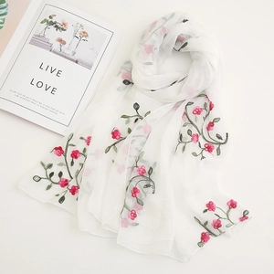 Detail shot of white chiffon scarf with pink floral embroidery and green leaves pattern