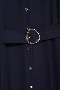 Detail of navy blue fabric with artistic gold waist buckle and metallic buttons