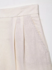 Detail of waist pleats and slanted pocket on beige cotton linen blend skirt