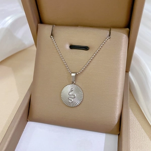 Close-up of silver titanium steel necklace with snake emblem pendant on silk