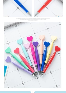 Detail showing various colors of heart-shaped plastic pens on white grid paper