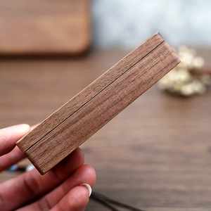 Close-up of closed mini black walnut jewelry box showing natural wood grain texture