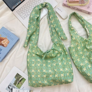 Detail of green floral canvas tote bag with bow strap and school lifestyle props