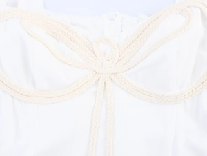 Detailed close-up of beige braided rope knot embroidery on a white puff sleeve dress