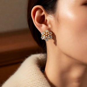 Macro detail of 14k gold plated flower stud earrings with sparkling crystals on model
