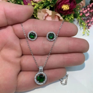 Detailopname van smaragdgroene sieradenset met ketting en ronde oorstekers
