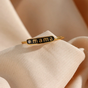 Macro detail of 18K gold plated mama ring with black enamel and a tiny crystal accent
