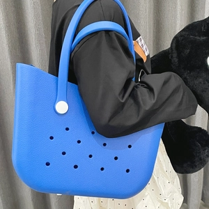 Blue EVA beach tote bag with perforated holes shown on a model with white polka dot skirt