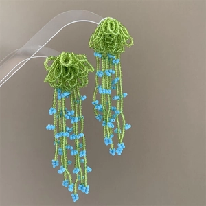 Handmade green floral beaded earrings with blue tassel fringe for summer beach vacation style