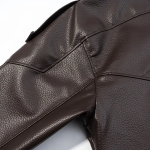 Macro view of dark brown PU leather jacket showing the detailed lychee grain texture