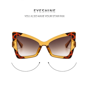 Detail of butterfly sunglasses with amber frames and leopard print accents