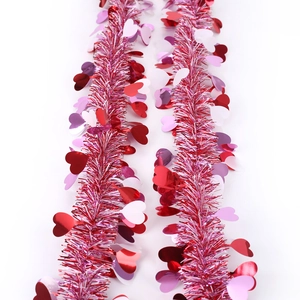 Close-up of pink and red tinsel garland with shiny heart-shaped sequins for party decor