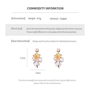 Detailed view of leaf earrings with gold and white enamel finish including dimensions