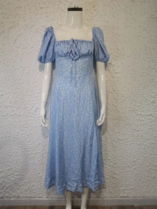 Detail of light blue floral midi dress featuring puff sleeves and tie-front neckline design
