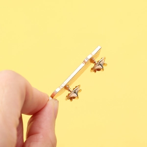 Golden stethoscope metal enamel brooch with dual pin clutch back on yellow background
