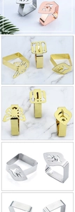 Detailed grid of leaf and butterfly stainless steel tablecloth clips in gold and silver