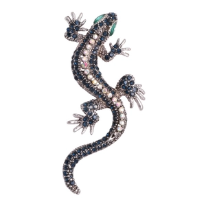 Elegant lizard brooch featuring vibrant blue crystals and green gemstone eyes on silver base