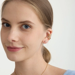 Orecchini a cuore in oro 18K e ear cuff multistrato con zirconi indossati da una modella