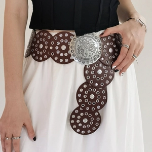 Détail de la ceinture bohème en cuir marron avec rivets argentés et boucle florale