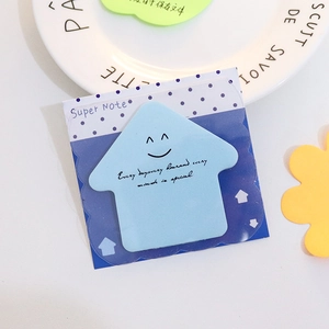 Blue house-shaped sticky notes with motivational quote on a decorative white plate